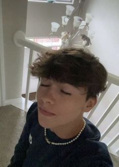 a young boy sitting on top of a white chair