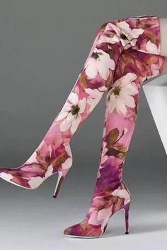 a woman wearing high heeled boots with flowers on the bottom and heels in front