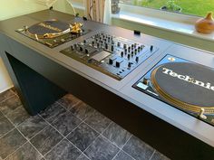 two turntables sitting on top of a table in front of a window