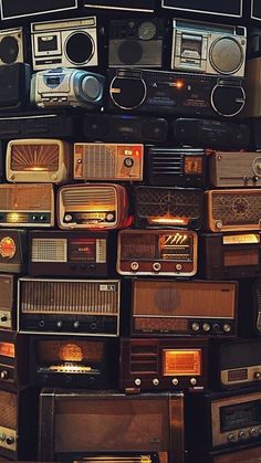 many old radio's are stacked on top of each other