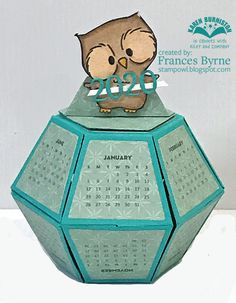 an owl is sitting on the top of a blue and green calendar ornament