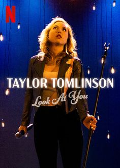 taylor tomasson looking up at the sky and holding a microphone in front of her