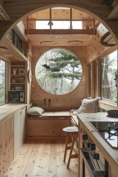 the inside of a tiny house with a circular window and wooden flooring is shown