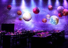 an image of a stage set up with planets on the wall and tables in front of it