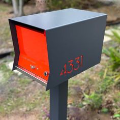 an orange and black mailbox with the number 350 on it's front side