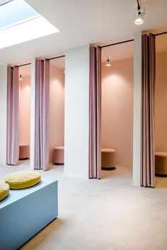 an image of the interior of a room with pink curtains and yellow pillows on it