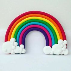 a rainbow made out of fondant sitting on top of a white table next to a wall