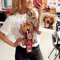 a woman is holding up a photo with a dog on it and wearing headphones