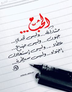 the writing is written in arabic on lined paper with a pen next to it,