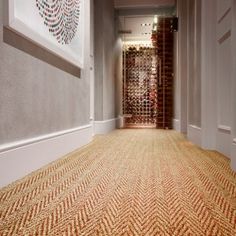 the hallway is lined with wine bottles and carpeted flooring that matches the walls