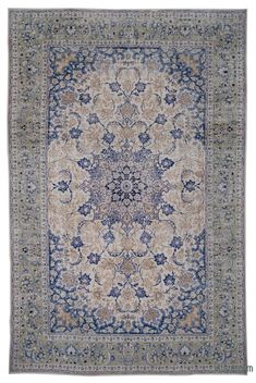 an antique persian rug with blue and beige colors on the center, surrounded by floral designs