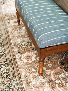 a wooden bench sitting on top of a rug