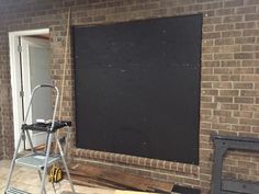 a brick wall with a blackboard on it and some tools in the foreground