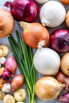 onions, scallions and green beans are laid out on a table top together