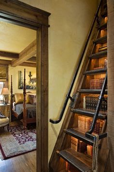 an open door leading to a living room with bookshelves on the wall and stairs