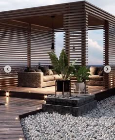 an outdoor living area with wooden slats on the walls and wood flooring, surrounded by pebbles