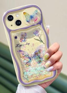 a woman holding up a phone case with butterflies on it