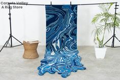 a blue and white marbled cloth hanging on a clothes line next to a potted plant