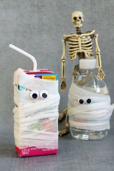 a skeleton next to a bottle with a toothbrush in it and a tube wrapped around it