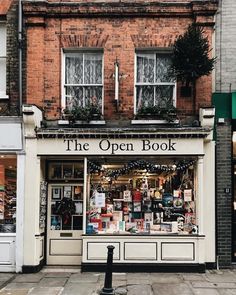 the open book store is located in an old brick building with white trim and windows