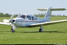 a small white plane sitting on top of a lush green field