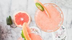 two margaritas with slices of grapefruit on the rim