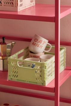 pink shelves with baskets and cups on them