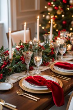 a christmas table setting with candles and greenery