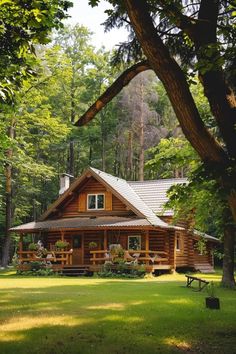 a log cabin sits in the middle of a wooded area with picnic tables and benches