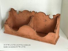 two clay planters sitting on top of a white shelf