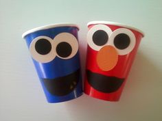 two paper cups with googly eyes and noses on them are sitting next to each other