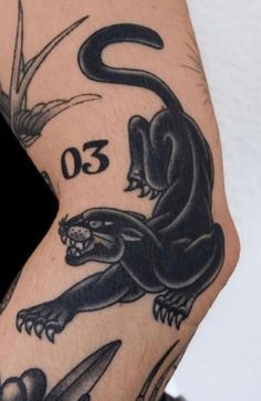 a man's arm with tattoos on it and an image of a black lizard