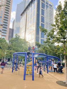 children play in the park with skyscrapers in the background at an outdoor playground area