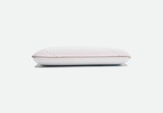 a white pillow sitting on top of a bed