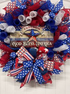 a patriotic wreath with red, white and blue ribbons