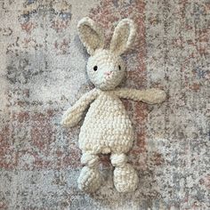 a crocheted stuffed animal laying on top of a rug