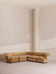 a beige couch sitting on top of a white floor