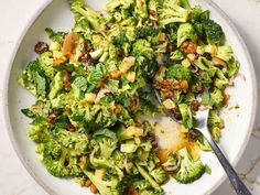 a white bowl filled with broccoli and other food on top of a table