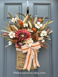 a basket filled with flowers sitting on top of a door