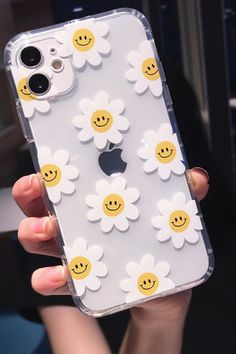 a person holding an iphone case with smiley face flowers on it's back and the phone