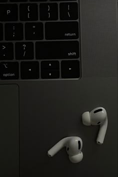 an apple laptop with ear buds attached to it