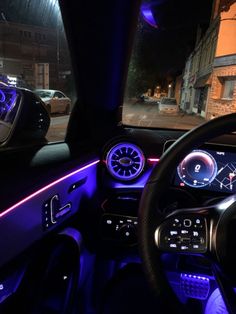 the interior of a car is lit up with blue lights and features steering wheel controls