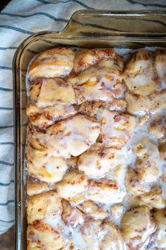 a pan filled with cinnamon rolls covered in icing