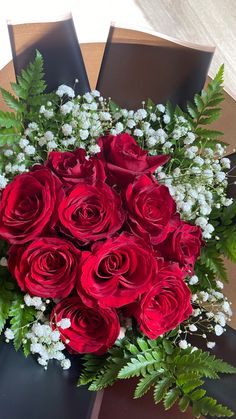 a bouquet of red roses sitting on top of a table