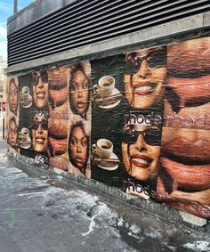 a large mural on the side of a building with coffee cups and women's faces