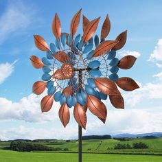 a large metal sculpture in the shape of a flower on top of a wooden pole