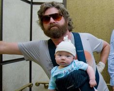 a man holding a baby in his sling