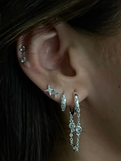 a close up of a person's ear with some piercings on it,