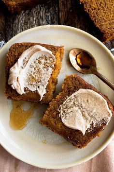 two pieces of cake on a plate with a spoon and honey syrup drizzled on top