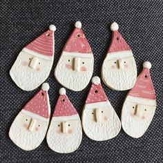 six ceramic christmas ornaments with santa hats and noses on them, all decorated in white and pink